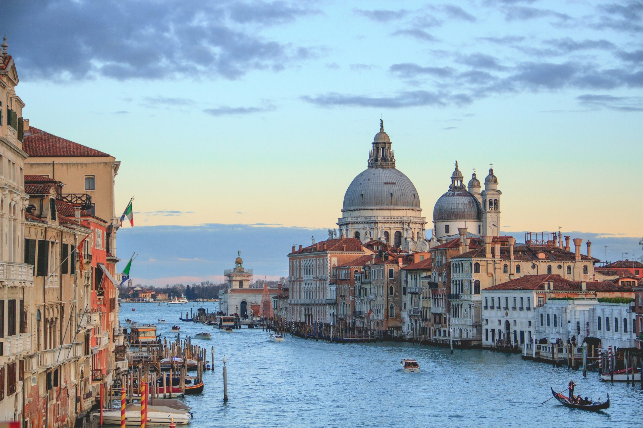 Vista del Gran Canal en Venecia con g&oacute;ndolas y arquitectura hist&oacute;rica, al atardecer, Italia. Ideal para paquetes tur&iacute;sticos en Italia 2025 y viajes de jubileo.