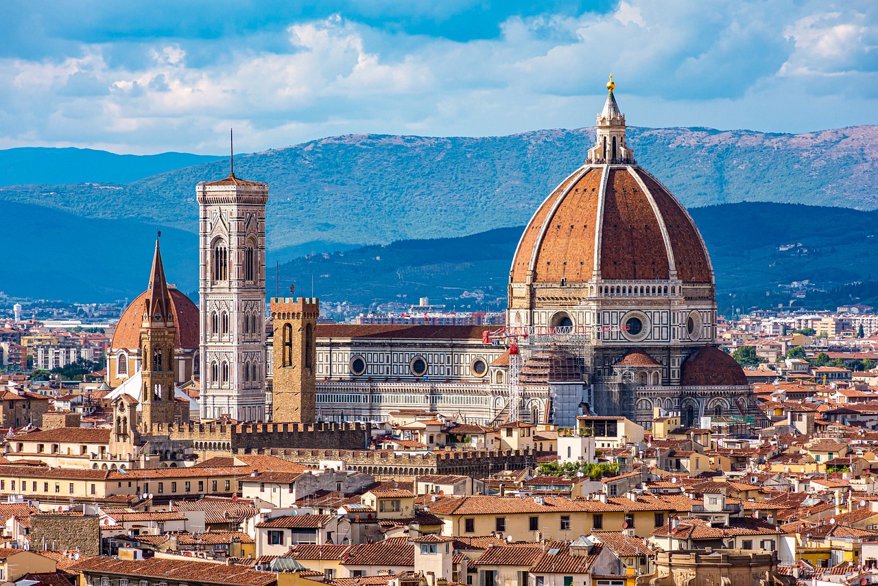 Vista panor&aacute;mica de la Catedral de Florencia con su ic&oacute;nica c&uacute;pula y el campanario, rodeada de edificios hist&oacute;ricos y las colinas toscanas al fondo, Italia 2025.